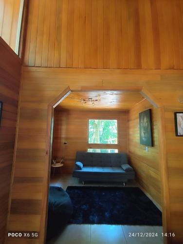 a room with a couch and a window in a house at Janela do céu chalés in Maquiné