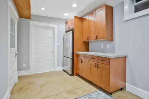 a kitchen with wooden cabinets and a refrigerator at Spacious 5 BR house - 5 Min Walk to N-MC Stadium in Annapolis