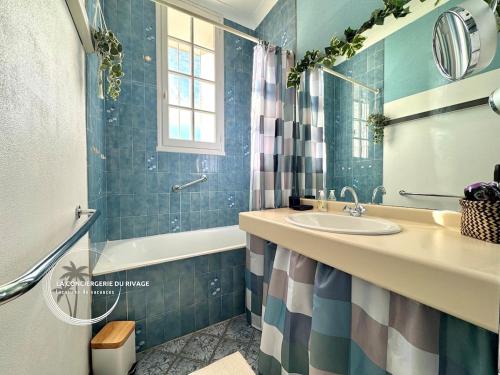 une salle de bain avec un lavabo et une baignoire dans l'établissement Le Mont des Oiseaux - Piscine - Vue panoramique, à Hyères