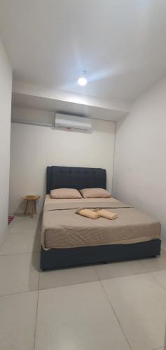 a bedroom with a bed in a white room at Ayesha Metrocity Staycation N-02 & N-5-03 in Kuching