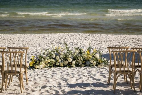 two chairs and a flower arrangement on the beach at SpringHill Suites by Marriott Navarre Beach in Navarre