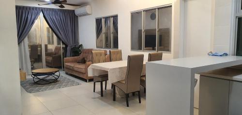 a kitchen and living room with a table and chairs at Ayesha Metrocity Staycation N-02 & N-5-03 in Kuching