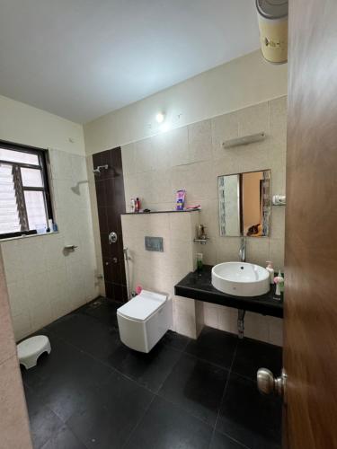 a bathroom with a white toilet and a sink at The Chapters in Goa