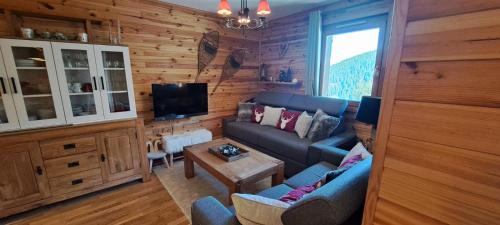 un salon avec un canapé et une table dans l'établissement Location appartement cosy, à La Plagne Tarentaise
