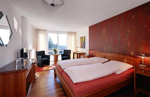 een slaapkamer met een groot bed met een rode muur bij Hotel Landhaus Berghof in Wenden