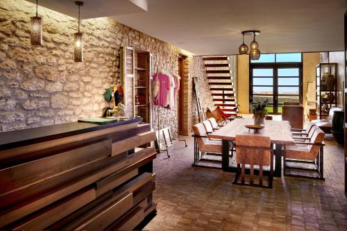 a living room with a table and a dining room at BABERRIH Hôtel Hospitality Palaces & Resorts in Essaouira