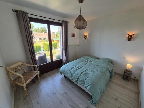 une chambre avec un lit, une chaise et une fenêtre dans l'établissement Cabana & Maison aux pieds du Semnoz, à Quintal