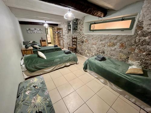 une chambre avec deux lits et un mur en pierre dans l'établissement Résidence Angela à 7 minutes à pieds du Palais, plage..., à Cannes