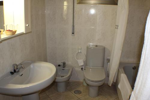 a bathroom with a sink and a toilet and a tub at Hotel Las Nieves in Las Nieves