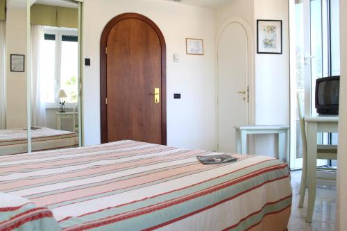a bedroom with a bed and a wooden door at Hotel Elena in Recco