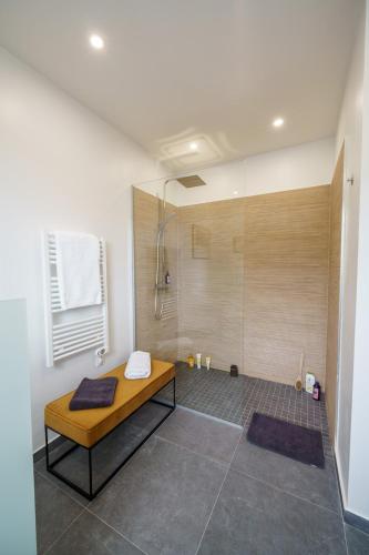 une salle de bain avec une douche avec un banc dedans dans l'établissement Magnifique Bastide des Oliviers classée 5 étoiles, à Tourrettes-sur-Loup