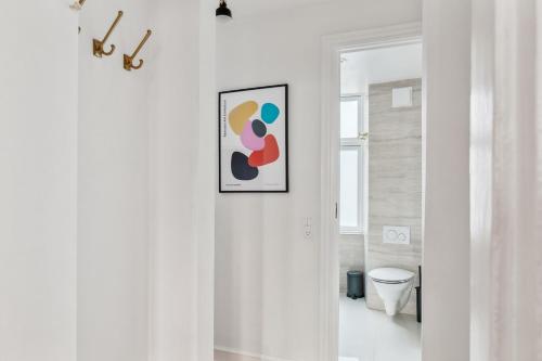 a hallway with a framed picture on a wall at Best Location - 5 Min To Tivoli And Main Station in Copenhagen