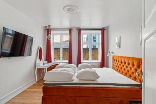 a bedroom with a bed with four pillows on it at Best Location - 5 Min To Tivoli And Main Station in Copenhagen