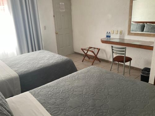 a hotel room with two beds and a counter at Hotel Camba in Oaxaca City