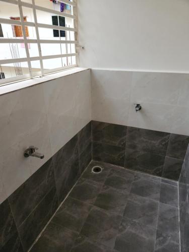 a bathroom with a shower with a tile floor at Modern New 2 BHK Studios in Kondapur Near Gachibowli in Hyderabad