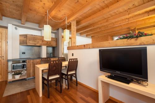 a kitchen with a dining table with chairs and a television at La Locandiera in Carona