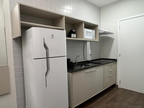 a kitchen with a refrigerator and a microwave at eSuites Sorocaba in Sorocaba