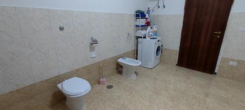 a bathroom with a toilet and a washing machine at Villa Pompei Oasis in Torre Annunziata