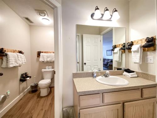 a bathroom with a sink and a toilet and a mirror at Inn Building Condo 113, Ground Level, Pool Side in Garden City