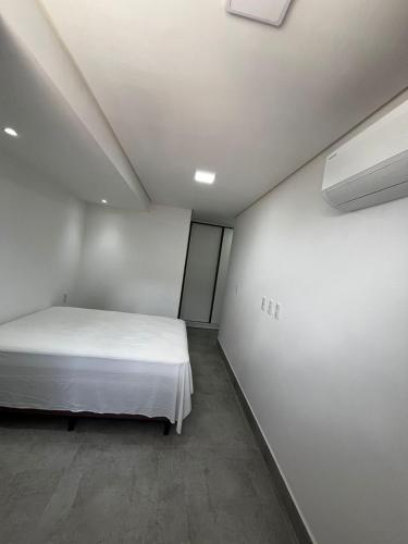 una camera da letto con un letto bianco in una stanza di APARTAMENTO EM CAMBOINHA PARA TEMPORADA EM JOÃO PESSOA, A 100M DO MAR E DE FRENTE A AREIA VERMELHAa a Cabedelo