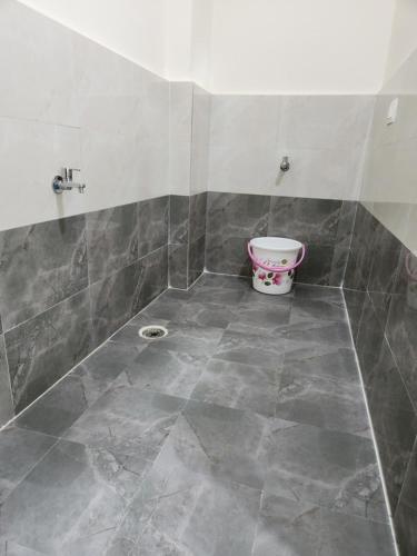 a bathroom with a bucket on a tiled floor at Modern New 2 BHK Studios in Kondapur Near Gachibowli in Hyderabad