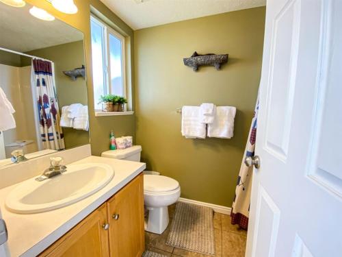 a bathroom with a sink and a toilet and a mirror at Lake View Condo 930 2 in Garden City