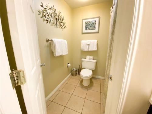 a bathroom with a toilet and towels at Inn Building Condo 103 updated, pool side view in Garden City