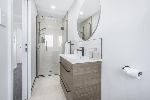 a bathroom with a sink and a mirror at Luxury, Modern with King Bed and Views- By KOSH BNB in Hamilton