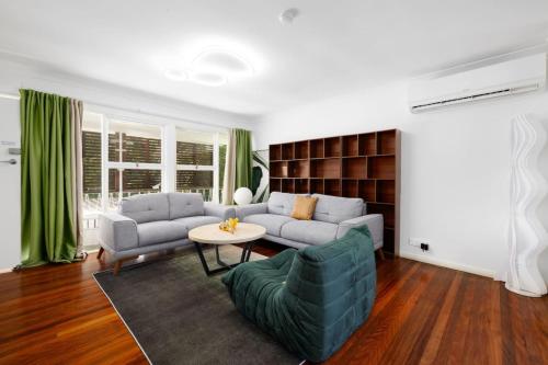 a living room with a couch and a table at Best Value 4Beds Home Near Shops, Cafes and Forest in Brisbane