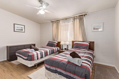 a bedroom with two beds and a ceiling fan at Relaxing 2BR plus Den Golf Retreat with Backyard and BBQ in Sun City