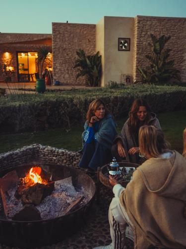 a group of people sitting around a fire pit at BABERRIH Hôtel Hospitality Palaces & Resorts in Essaouira