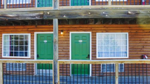 a log cabin with green doors and windows at Jonesbones Room at White Wing Lodge- Silver Dollar City Getaway in Branson