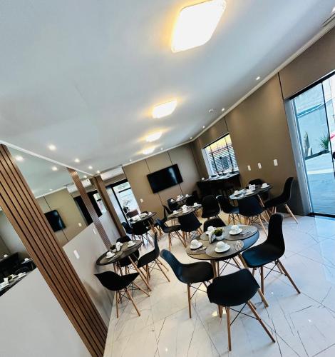 a restaurant with tables and chairs in a room at Hotel Aris in União da Vitória