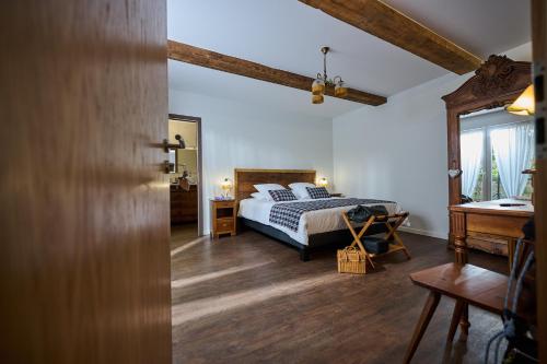 a bedroom with a bed and a table and a mirror at Le Clos de la Vieille Dame in Sessenheim