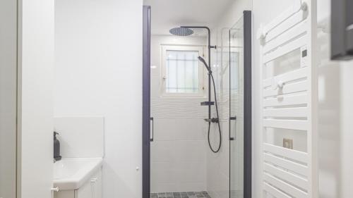 une douche avec une porte vitrée dans une salle de bain dans l'établissement L'Élégance Troyenne - Prox Hotel de Ville, à Troyes