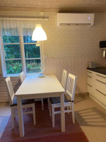 a white table and chairs in a kitchen at Kleines Haus in Schweden in Viksjö