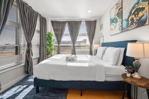 a bedroom with a large bed and two windows at Beautiful 2BR in Southend Boston in Boston