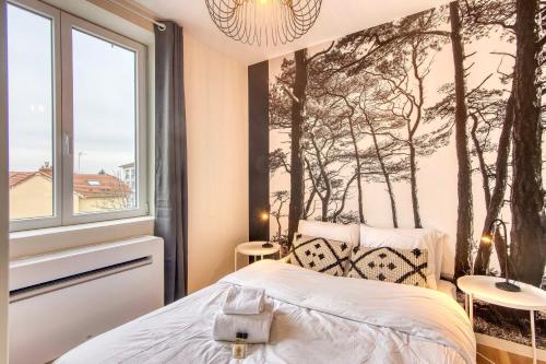 - une chambre avec une fresque murale sur les arbres dans l'établissement Le Cèdre Bleu - Bel appart climatisé quartier point du jour Lyon 5, à Lyon