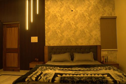 a bedroom with a bed with a stone wall at Himalayan Manor in Dehradun