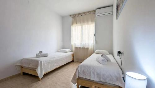 una camera da letto con due letti e una finestra di Paraiso del Sol a Denia