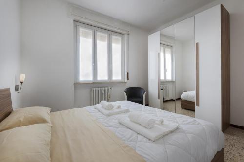 a bedroom with a large white bed with two towels on it at San Macario House MXP Airport in Samarate