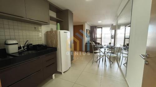 a kitchen with a white refrigerator and a table at Eco Summer Tambaú WB Genius Flats in João Pessoa