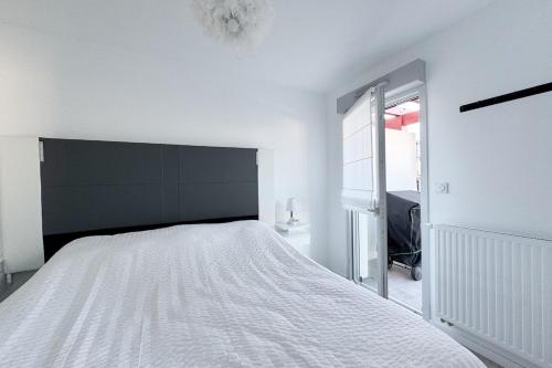 une chambre blanche avec un grand lit et une fenêtre dans l'établissement Le Karzingo Borda, à Saint-Jean-de-Luz