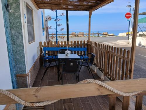 a porch with a table and chairs and the ocean at La casita salinera in El Pozo del Cabo
