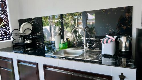 a kitchen with a sink and a counter top at Jasmine Village in Rawai Beach
