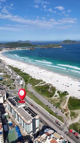 a view of a beach with a red sign at Apart Hotel Porto Príncipe in Cabo Frio