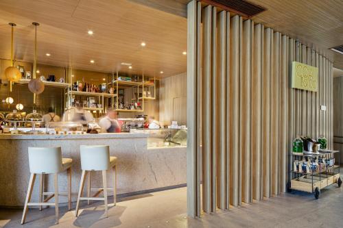 a restaurant with two white stools in front of a counter at Fairmont Rio de Janeiro Copacabana in Rio de Janeiro