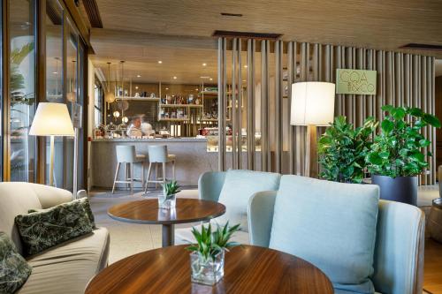 a lobby with chairs and tables and a bar at Fairmont Rio de Janeiro Copacabana in Rio de Janeiro