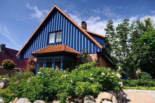 a blue and white house with flowers in front of it at Blaues Haus in Glückstadt