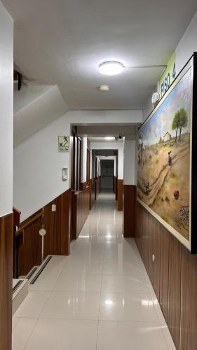 a hallway in a building with a large painting on the wall at Hoteles Perla del Chira in Piura